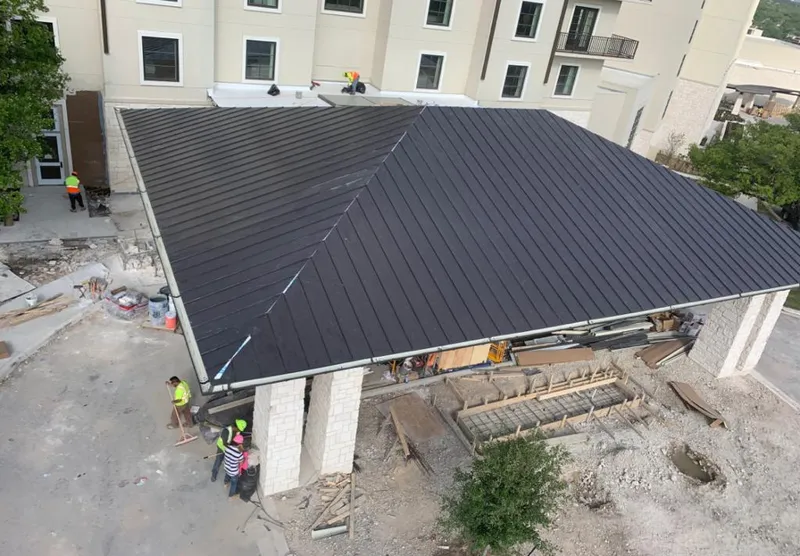 Metal roofing installation team working on a commercial building in Orono